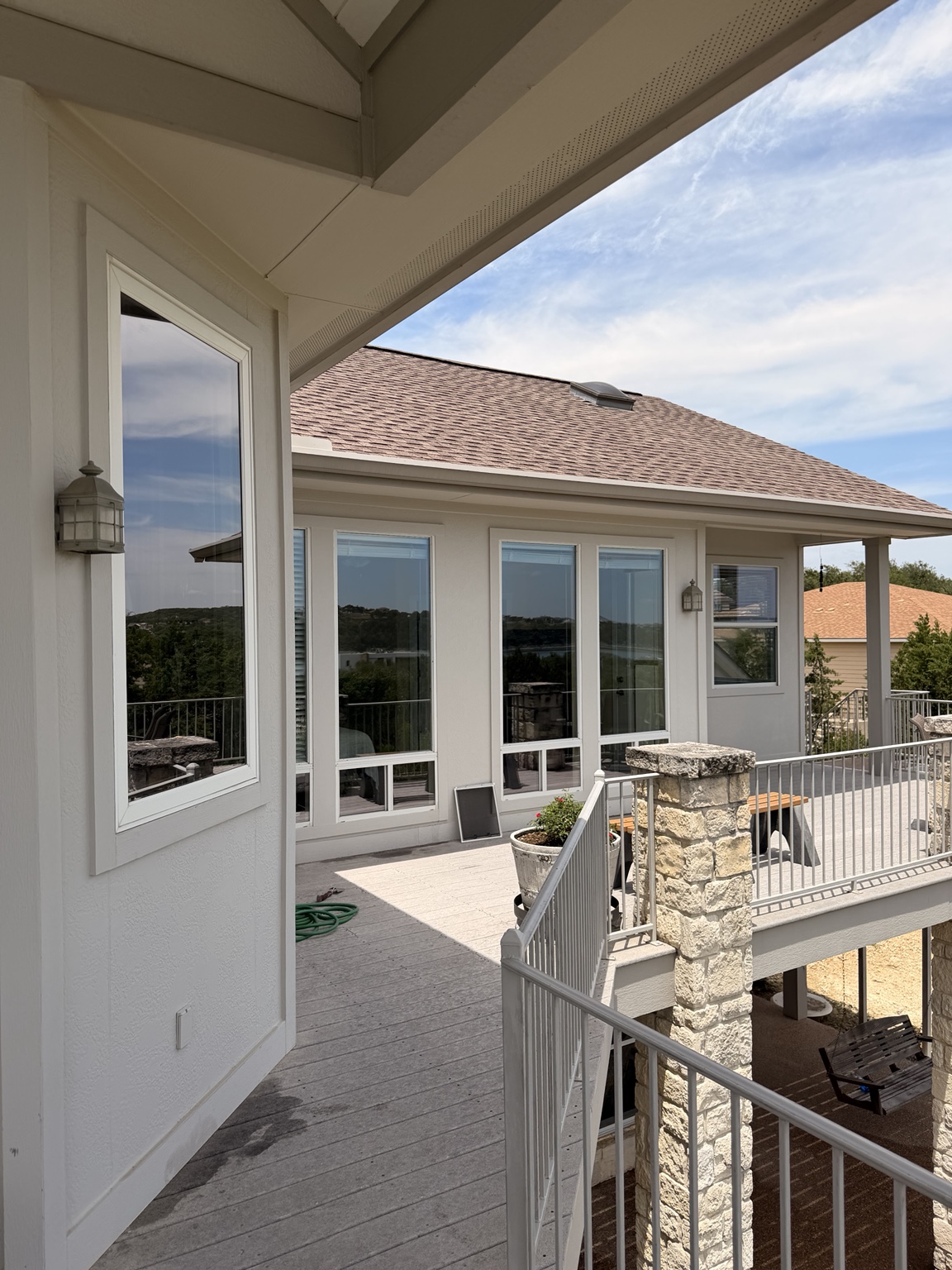 Modern white luxury home upper deck with floor-to-ceiling glass — Lake Travis, TX